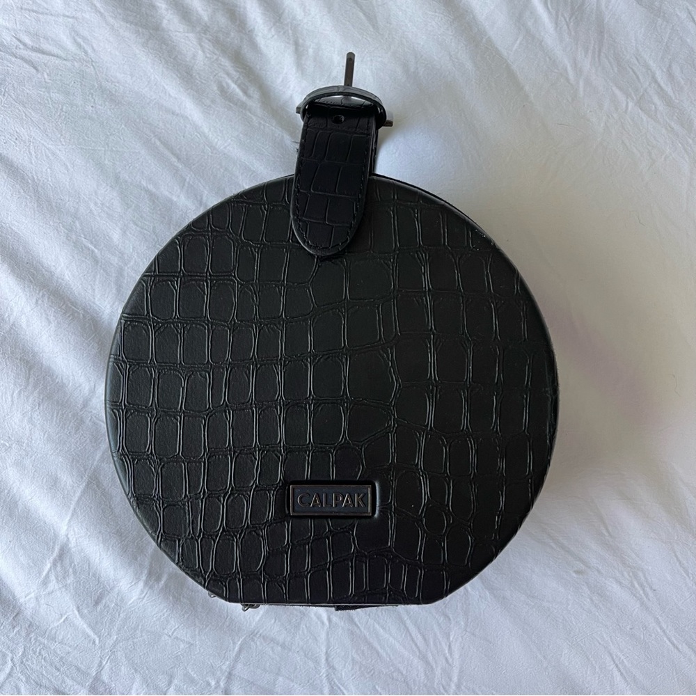 CALPAK ROUND BUCKLE TOP ZIP AROUND TRAVEL CASE